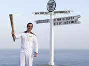 British Olympic sailing hero and three time gold medalist Ben Ainslie holds the Olympic torch at the official start of the London 2012 Olympic games torch relay at Land`s End, south west England.