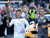 Torchbearer 140 Lord Sebastian Coe carries the Olympic Flame on the Torch Relay leg through Sheffield, England.