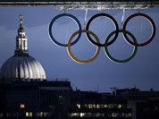 St. Paul`s Cathedral is seen in the distance as the Olympic rings hang from the Tower Bridge in London. 