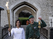 British retired champion Dame Kelly Holmes, left, poses for the photographers with the Olympic flame, along with British Royal Marine Martyn Williams, 23, right, who abseiled from a Sea King helicopter, with the lantern with the Olympic flame strapped to his body, at the Tower of London.