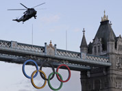 A British Royal Marine Sea King helicopter carrying the Olympic flame flies past the Tower Bridge in London, as it arrives to the Tower of London.