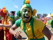Artists cheer as members of the South African Olympic delegation arrive for the flag raising ceremony at the Olympic Village in London.