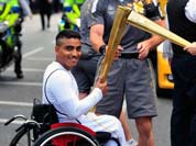 Photo provided by LOCOG, singer Paloma Faith passes the Olympic Flame to torchbearer Sheikh Sheikh on the Torch Relay leg through London.