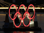 A set of Olympic Rings float on a barge in the River Thames off of Battersea park in London. 