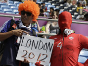 A Canadian masked fan and Japan fan, posing for a picture during the group F soccer match between Japan and Canada at the London 2012 Summer Olympics.