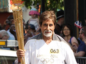 In this photo provided by LOCOG, Amitabh Bachchan carries the Olympic flame on the torch relay leg between The City of London and the borough of Southwark in London.