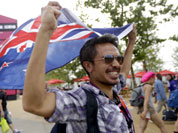Zaki Abdullah carries a New Zealand flag as he walks into the Olympic Park before the Opening Ceremony for the 2012 Summer Olympics in London.