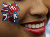 A young woman wears a London Olympics logo on her cheek outside the Olympic Park ahead of the 2012 Summer Olympics Opening Ceremony in London.