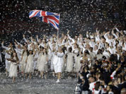 Great Britain`s Chris Hoy carries the national flag as confetti surrounds the team during the Opening Ceremony at the 2012 Summer Olympics in London.