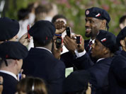 Professional basketball player LeBron James takes pictures with members of the the United States` Olympic team during the Opening Ceremony at the 2012 Summer Olympics in London.