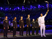 Steve Redgrave, right, holds the Olympic torch after entering the stadium during the Opening Ceremony at the 2012 Summer Olympics in London.