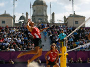 Ruslans Sorokins, left from Latvia leaps to spike a ball during the Beach Volleyball match against Poland at the 2012 Summer Olympics.