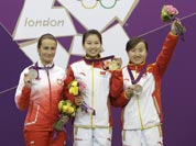 China`s Yi Siling, center, celebrates winning the gold medal in the women`s 10-meter air rifle event, alongside silver medalist Poland`s Sylwia Bogacka, left, and bronze medalist China`s Yu Dan, right, at the 2012 Summer Olympics.