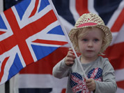 A young girl shows her support for the Great Britain team at a park screening a live telecast of the opening ceremony of the 2012 Summer Olympics in London.