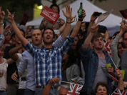 Visitors at a park celebrate during the live telecast of the Opening Ceremony of the 2012 Summer Olympics in London. 