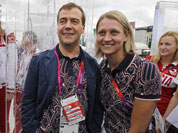 Russian Prime Minister Dmitry Medvedev center, poses with Russian Olympics team members during his visits to Olympic village at the 2012 Summer Olympics, in London.