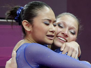 Brazilian gymnast Ethiene Cristina Gonser Franco, right, hugs teammate Harumy Mariko de Freitas, left, during the artistic gymnastics women`s qualification at the 2012 Summer Olympics in London.