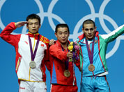 North Korea`s Om Yun Chol, center, celebrates winning the gold with China`s silver medal winner Wu Jingbiao, left, and Azerbaijan`s bronze medal winner Valentin Hristov in the men`s 56kg weightlifting competition at the 2012 Summer Olympics.