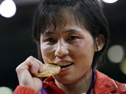 North Korea`s An Kum Ae, of North Korea, bites her gold medal from the women`s 52-kg judo competition at the 2012 Summer Olympics.