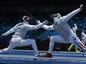 Radu Daraban of Romania, left, and Valerio Aspromonte of Italy compete during his men`s individual foil fencing match against Mohamed Samandi of Tunisia at the 2012 Summer Olympics.