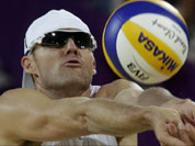 Jacob Gibb of the United States sets the ball during a loss to Poland during a beach volleyball match at the 2012 Summer Olympics in London. 