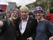 London Mayor Boris Johnson, poses for pictures with Britain team fans, following a photo-op with London ambassadors, the volunteers working around the city to give tourists directions and information, in central London.