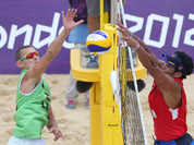 Martins Plavins, from Latvia spikes a ball past Igor Hernandez, from Venezuela during their Beach Volleyball match at the 2012 Summer Olympics in London.