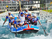 Torchbearer 024 Zachary Franklin carrying the Olympic Flame on a raft down the Lee Valley White Water Centre on the Torch Relay leg between Harlow and Waltham Cross, north of London.