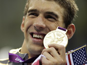 United States` Michael Phelps poses with his gold medal for the men`s 4x200-meter freestyle relay swimming final at the Aquatics Centre in the Olympic Park during the 2012 Summer Olympics in London.