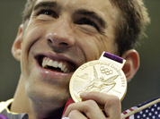 United States` Michael Phelps poses with his gold medal for the men`s 4x200-meter freestyle relay swimming final at the Aquatics Centre in the Olympic Park during the 2012 Summer Olympics in London.