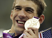 United States` Michael Phelps poses with his gold medal for the men`s 4x200-meter freestyle relay swimming final at the Aquatics Centre in the Olympic Park during the 2012 Summer Olympics in London.