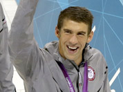 United States swim team members, from left, Ryan Lochte, Conor Dwyer, Ricky Berens and Michael Phelps walk with a U.S. flag after being awarded the gold medal for their win in the men`s 4 x 200-meter freestyle relay at the Aquatics Centre in the Olympic Park during the 2012 Summer Olympics in London
