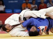 Jevgenijs Borodavko of Latvia competes against Anthony Liu of American Samoa (in blue) during the men`s 100-kg judo competition at the 2012 Summer Olympics.