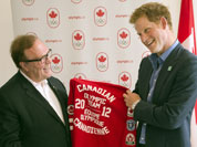 Prince Harry receives a Canadian team jacket from Canadian Olympic Committee President Marcel Aubut during his visit to Canada House at the 2012 Summer Olympics.