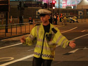 A police officer stands at the scene where the driver of an official Olympic bus carrying journalists has been arrested after a bicyclist was hit and killed, near the Olympic Park in Stratford, London.