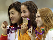 China`s Tang Yi, Netherlands` Ranomi Kromowidjojo and Belarus` Aliaksandra Herasimenia pose with their medals for the women`s 100-meter freestyle swimming final at the Aquatics Centre in the Olympic Park during the 2012 Summer Olympics in London.