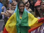Ethiopia`s gold medal winner Tiki Gelana celebrates with her country`s flag after the women`s marathon at the 2012 Summer Olympics.