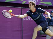Andy Murray of Great Britain returns to Roger Federer of Switzerland during the gold medal men`s singles match at the All England Lawn Tennis Club in Wimbledon, London at the 2012 Summer Olympics.