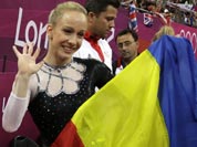 Romania`s gymnast Sandra Raluca Izbasa holds her national flag and celebrates after winning the gold medal for the artistic gymnastics women`s vault finals at the 2012 Summer Olympics.