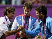 Silver medalist Switzerland`s Roger Federer, right, shakes hands with bronze medalist Juan Martin del Potro of Argentina, right, as Gold medalist Andy Murray of Great Britain, center, stands during the medal ceremony of the men`s singles event at the All England Lawn Tennis Club at Wimbledon in London Olympics