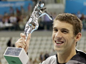 United States` swimmer Michael Phelps holds up a silver trophy after being honored as the most decorated Olympian at the Aquatics Centre in the Olympic Park during the 2012 Summer Olympics in London