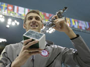 United States` swimmer Michael Phelps holds up a silver trophy after being honored as the most decorated Olympian at the Aquatics Centre in the Olympic Park during the 2012 Summer Olympics in London