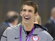 United States` swimmer Michael Phelps smiles as he wears his gold medal at the Aquatics Centre in the Olympic Park during the 2012 Summer Olympics.