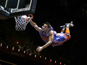 An ariel performer flies and slams a dunk during halftime of a women`s basketball game between Russia and France at the 2012 Summer Olympics.