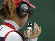 United States of America`s Corey Cogdell holds her gun, with fingernails painted in designs in the colors of the U.S. flag, as she waits her turn to shoot, during qualifiers for the women`s trap event, at the 2012 Summer Olympics.