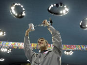 United States` swimmer Michael Phelps holds up a silver trophy after being honored as the most decorated Olympian at the Aquatics Centre in the Olympic Park during the 2012 Summer Olympics in London