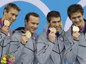 United States` men`s 4 X 100-meter medley relay team from left, Matthew Grevers, Brendan Hansen, Michael Phelps and Nathan Adrian hold their gold medals at the Aquatics Centre in the Olympic Park during the 2012 Summer Olympics in London