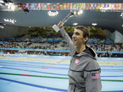 United States` swimmer Michael Phelps holds up a silver trophy after being honored as the most decorated Olympian at the Aquatics Centre in the Olympic Park during the 2012 Summer Olympics in London
