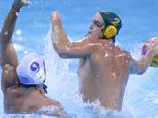 Richie Campbell of Australia takes a shot at goal as Georgios Afroudakis of Greece goes to block the attempt during their men`s water polo preliminary round match at the 2012 Summer Olympics.