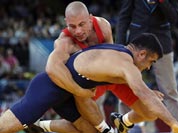 Damian Janikowski of Poland competes against Nazmi Avluca of Turkey (in blue) during the 84-kg Greco-Roman wrestling competition at the 2012 Summer Olympics.